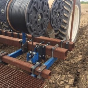 Tractor with spools on a farm field.