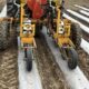 Tractor planting seeds in prepared soil rows.
